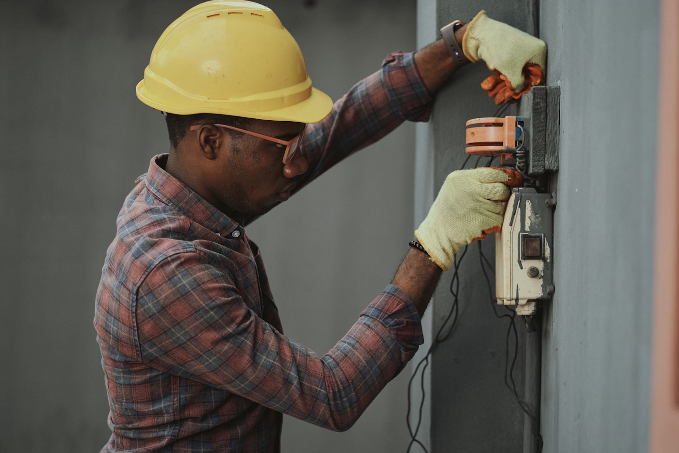 Electrician in a hard hat working on a panel