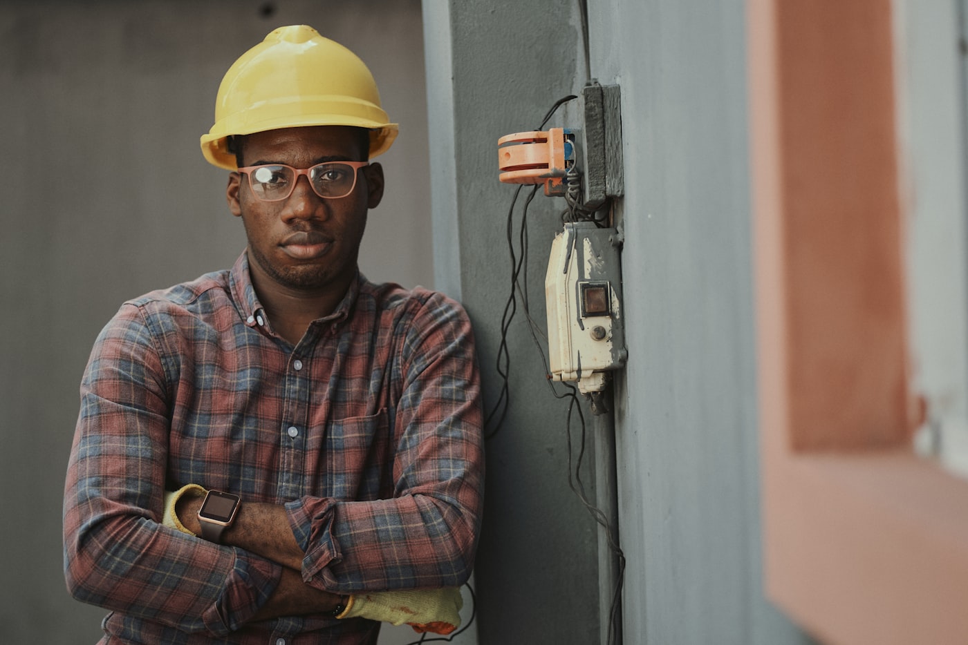 Technician in a hard hat standing by an electrical box